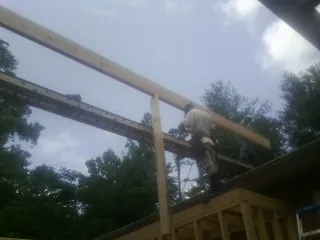 Carpenter setting a ridge beam over a new addition frame — Ice Dam Removal by Roofing Brothers in Curlew