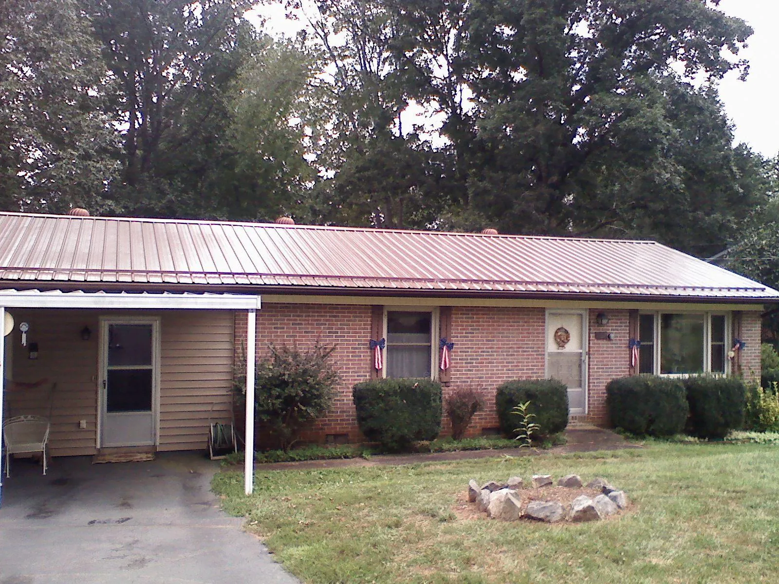 Bronze metal roof and carport on a brick ranch home — Roof Repair work by our crew in Curlew